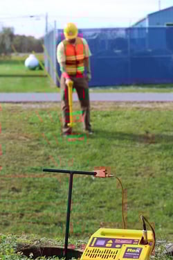 Worker with Schonstedt pipe and cable locator in field